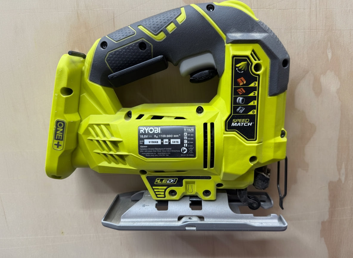 Green and black Ryobi power tool on a wooden surface